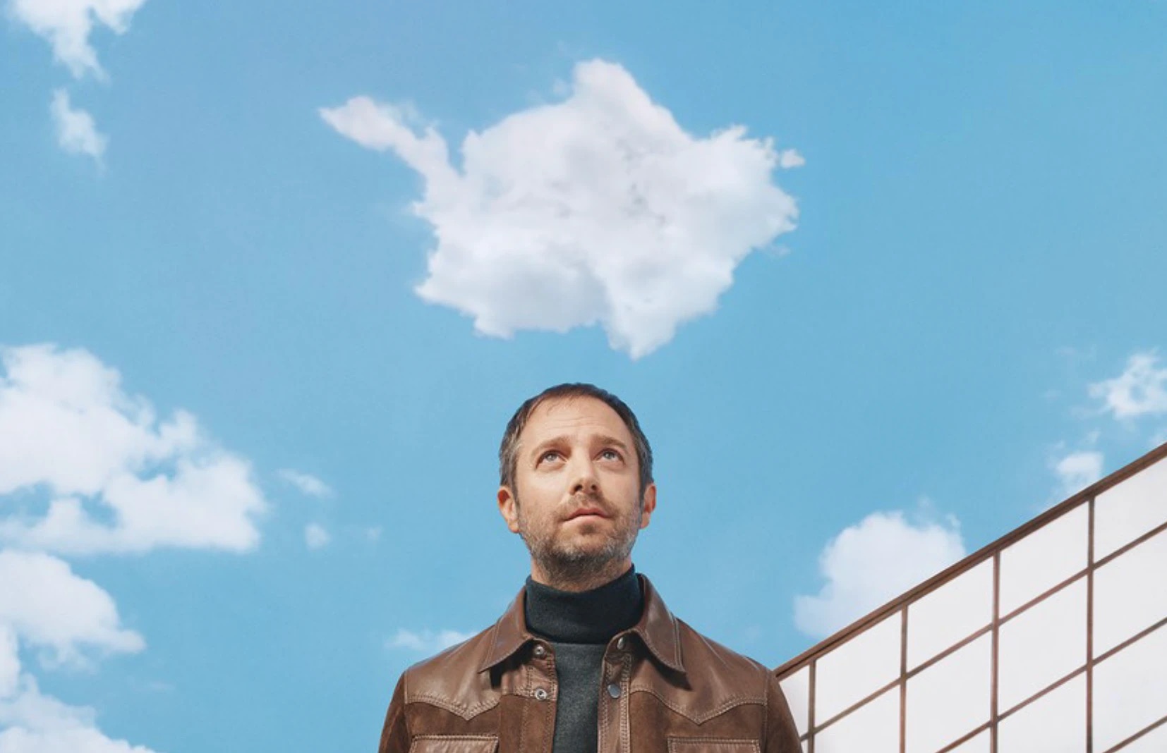 Leandro Erlich lève les yeux vers un nuage de son installation "Sous le Ciel" au Bon Marché Rive Gauche
